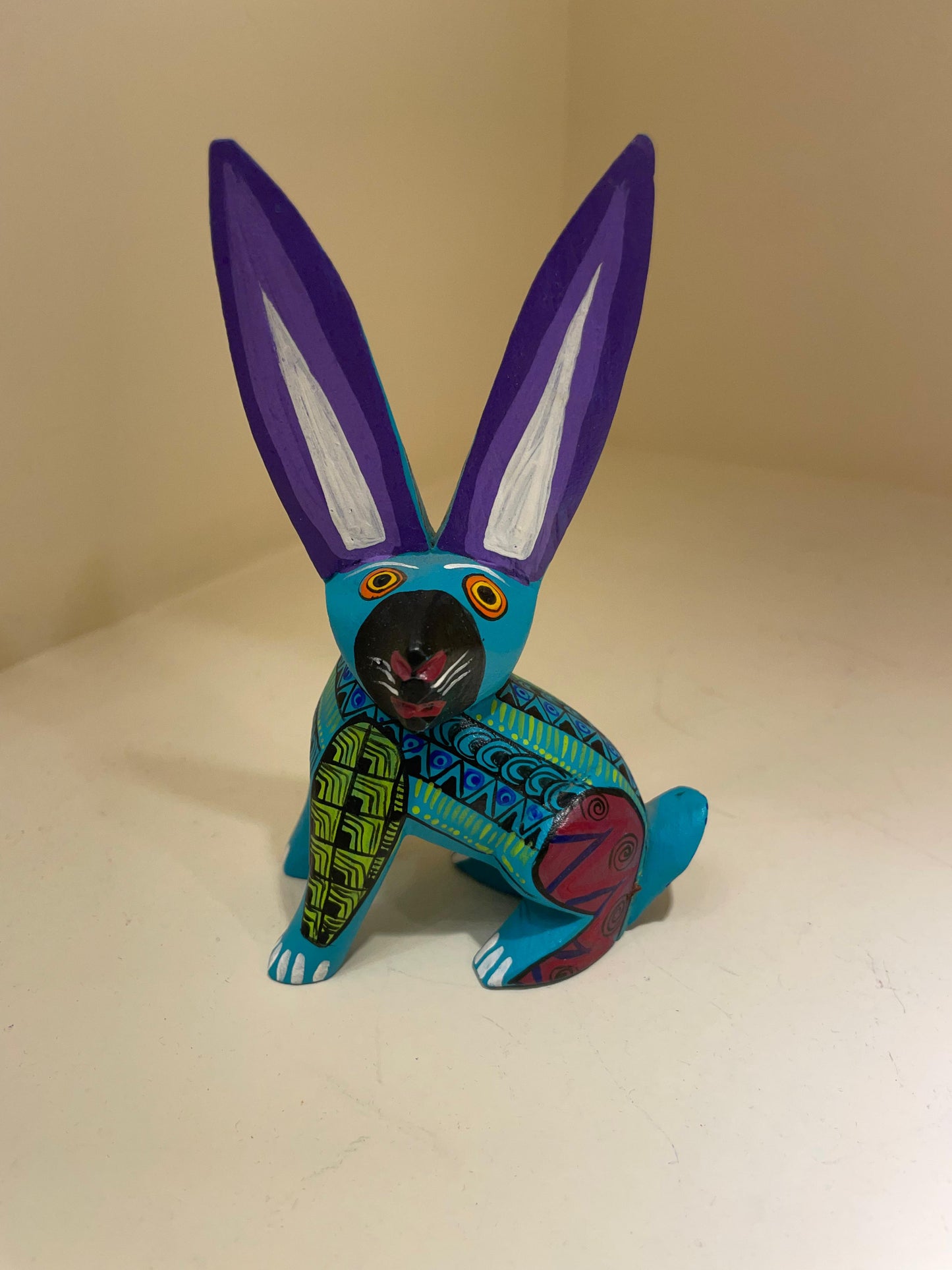 Alebrije de liebre azul con orejas moradas e iconografía zapoteca – San Martín Tilcajete Oaxaca