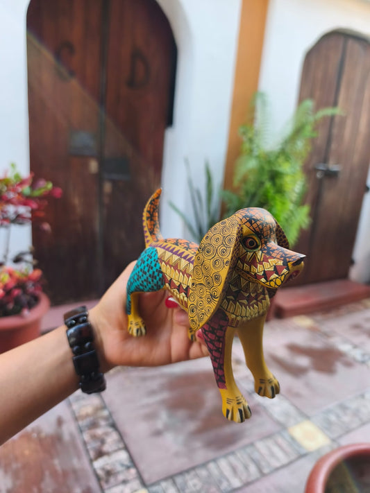 Perro Alebrije de madera tallada y pintada en colores vibrantes – Hecho a mano en San Martín Tilcajete, Oaxaca.